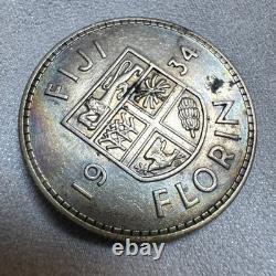 Pièce de 1 florin des Fidji de 1934 en argent, patine irisée arc-en-ciel aux reflets huileux sur le pourtour, non circulée (UNC), rare Pièce de 1 florin des Fidji de 1934 en argent, patine irisée arc-en-ciel aux reflets huileux sur le pourtour, non circulée (UNC), rare
