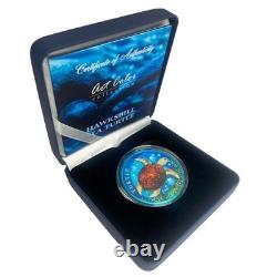 Pièce en argent colorisée de 1 oz représentant une tortue de Nouvelle-Zélande, couleur bleue spatiale, avec boîte et certificat d'authenticité.